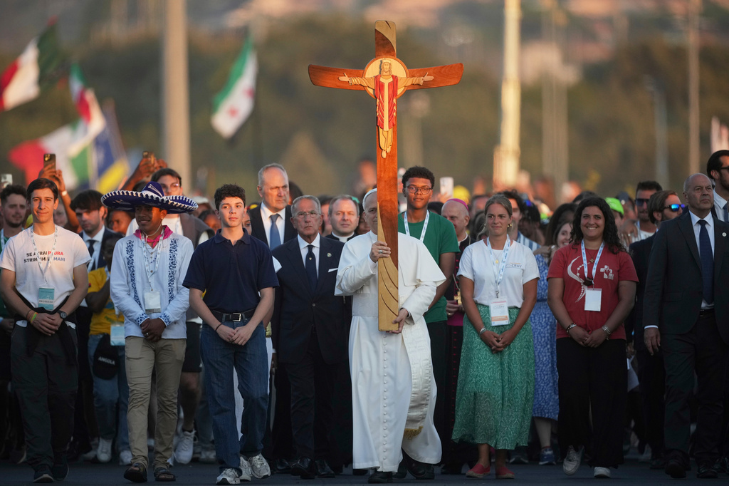 FILE - Pope Leo XIV carries a cross as he leads a Youths Jubilee prayer vigil at the Tor Vergata field in Rome, Aug. 2, 2025. (AP Photo/Andrew Medichini, File)