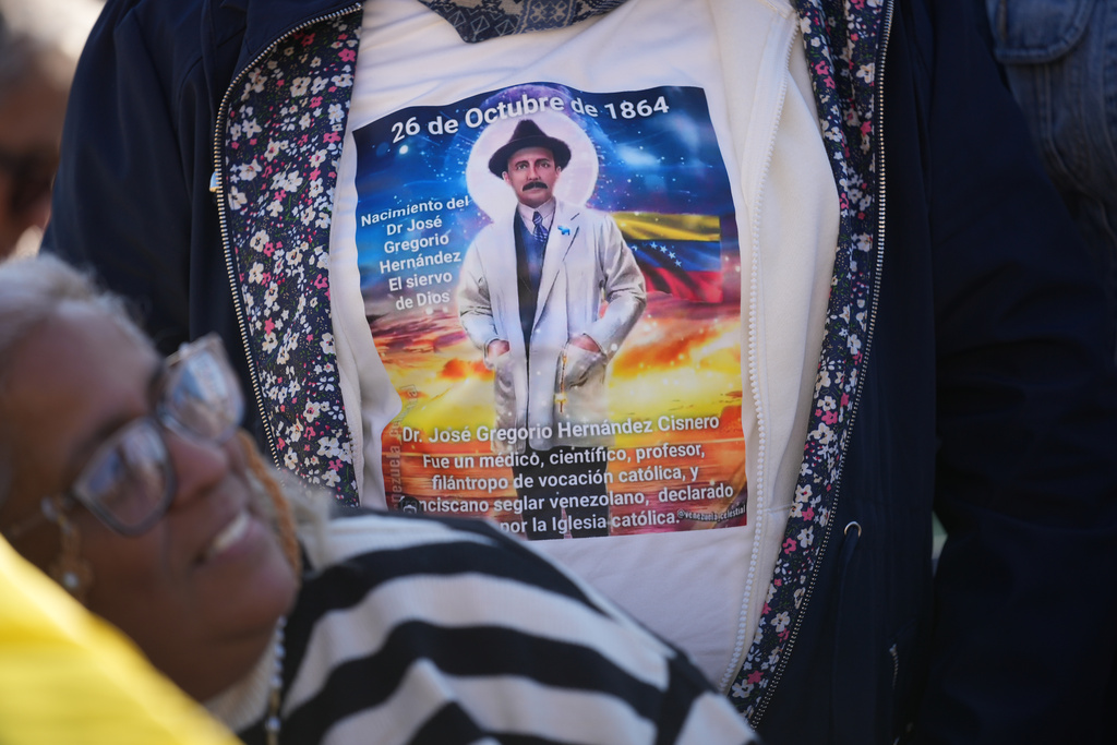 Pilgrims and faithful wear t-shirts carrying the image of soon-to-be-canonized Venezuelan doctor José Gregorio Hernández wait for the arrival of Pope Leo XIV, who will preside over a Mass in St. Peter's Square at the Vatican during which he will canonize seven new saints of the Catholic Church, Sunday, Oct. 19, 2025. (AP Photo/Andrew Medichini)