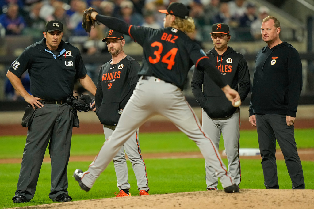 Baltimore Orioles manager Craig Albernaz, second from left, and others watch as pitcher Shane Baz, center, tests his arm after he was hit by a ball during the fifth inning of a baseball game against the New York Mets, Tuesday, Sept. 15, 2026, in New York. (AP Photo/Seth Wenig)