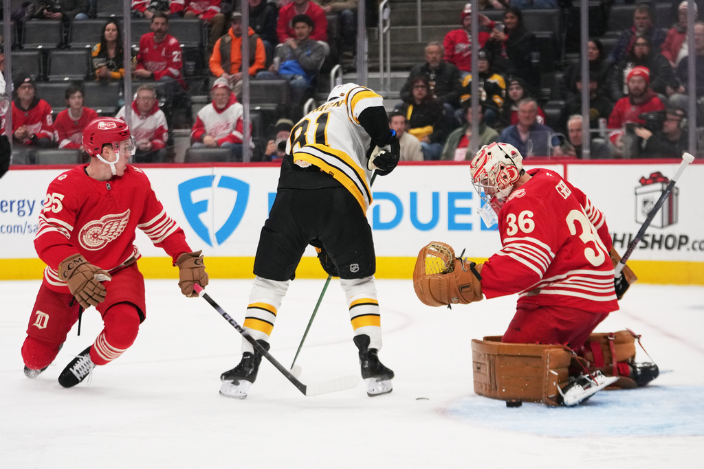 Detroit Red Wings goaltender John Gibson (36) stops a Boston Bruins center Michael Eyssimont (81) shot as Jacob Bernard-Docker (25) defends in the first period of an NHL hockey game Tuesday, Dec. 2, 2025, in Detroit. (AP Photo/Paul Sancya)