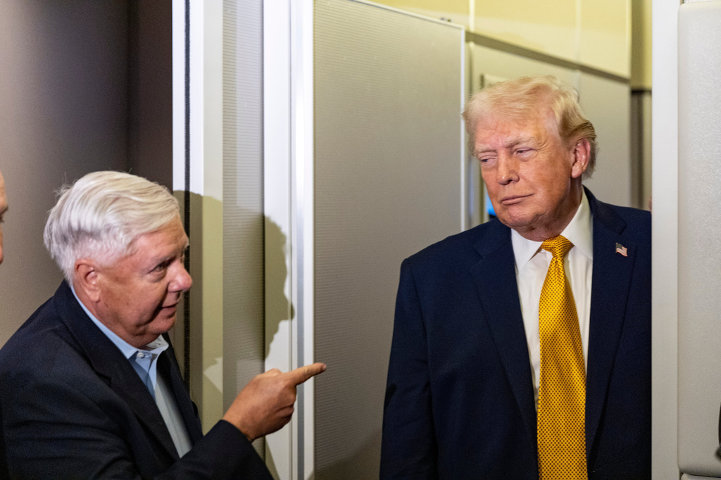 FILE - Sen. Lindsey Graham, R-S.C., left, gestures as President Donald Trump speaks with reporters while in flight on Air Force One, Jan. 4, 2026, as they were returning to Joint Base Andrews, Md. (AP Photo/Alex Brandon, File)