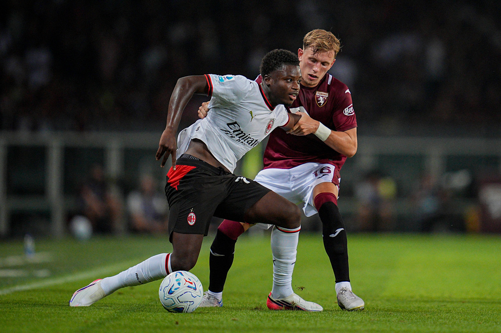 Milan's Alphadjo Cisse, left, fights for the ball with Torino FC's Marcus Pedersen during to the Serie A soccer match between Torino and Milan at the Stadio Olimpico Grande Torino in Turin, Italy, Sunday, Aug. 23, 2026 (Marco Alpozzi/LaPresse via AP)