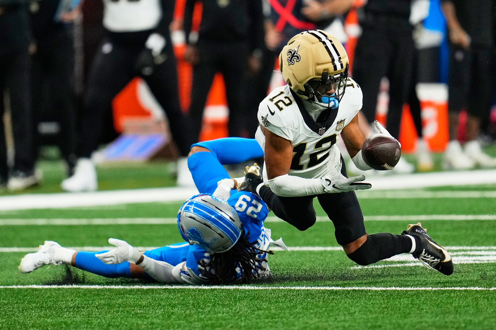 New Orleans Saints wide receiver Chris Olave (12) can't hold onto a pass as he is defended by Detroit Lions cornerback Avonte Maddox (29) in the first half of an NFL football game, Sunday, Sept. 13, 2026, in Detroit. (AP Photo/Paul Sancya)