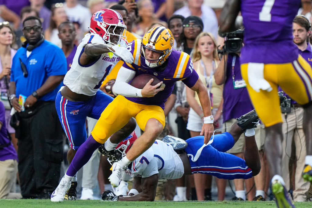 LSU quarterback Sam Leavitt (10) is tackled by Louisiana Tech defensive back Sam Fongang (1) and defensive back Janard Lockhardt (7) in the first half of an NCAA college football game, Saturday, Sept. 12, 2026 in Baton Rouge, La. (AP Photo/Gerald Herbert)