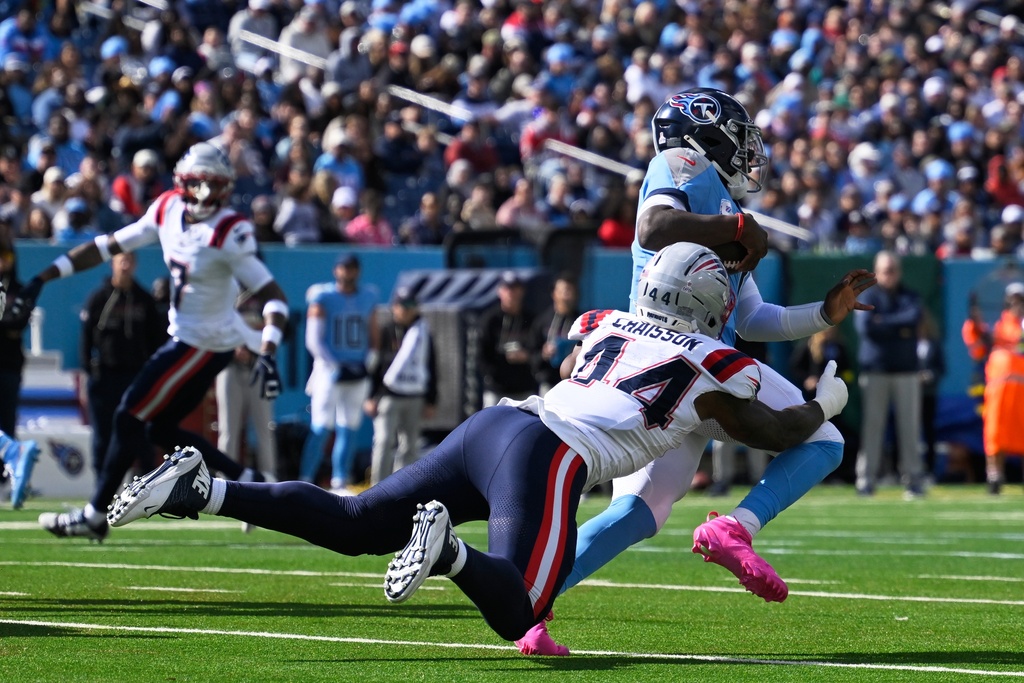 Tennessee Titans quarterback Cam Ward (1) is tackled by New England Patriots linebacker K'Lavon Chaisson (44) during the second half of an NFL football game, Sunday, Oct. 19, 2025, in Nashville, Tenn. (AP Photo/John Amis)