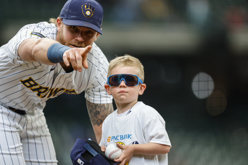 Milwaukee Brewers first baseman Jake Bauers (9) points a small boy back to the stands after signing an autograph before the first inning of a baseball game against the Pittsburgh Pirates Sunday, April 26, 2026, in Milwaukee. (AP Photo/Jeffrey Phelps)