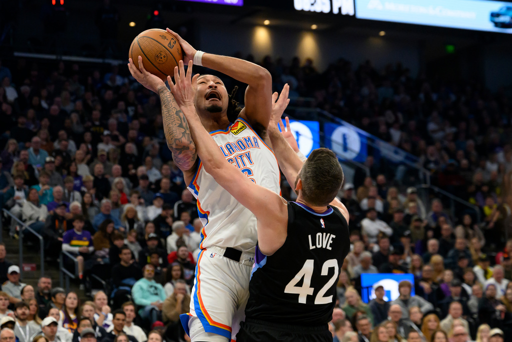 Oklahoma City Thunder forward Jaylin Williams, rear, drives to the basket guarded by Utah Jazz forward Kevin Love (42) during the first half of an NBA Cup basketball game, Friday, Nov. 21, 2025, in Salt Lake City. (AP Photo/Tyler Tate)