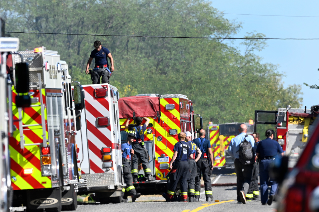 Fire department personnel stand along McCandlish Road near a shooting that took place at The Church of Jesus Christ of Latter-day Saints, Sunday, Sept. 28, 2025, in Grand Blanc, Mich. (AP Photo/Jose Juarez)
