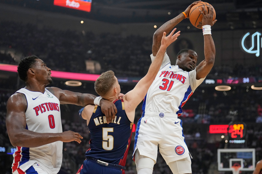 Detroit Pistons guard Javonte Green (31) grabs a rebound in front of Cleveland Cavaliers guard Sam Merrill (5) and teammate Jalen Duren (0) half of Game 3 of a second-round NBA playoffs basketball series Saturday, May 9, 2026 in Cleveland. (AP Photo/Sue Ogrocki)