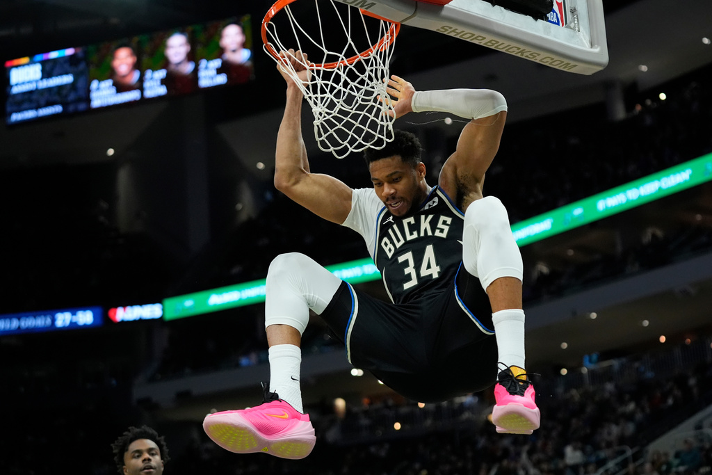 Milwaukee Bucks' Giannis Antetokounmpo hangs on the rim after dunking during the second half of an NBA basketball game against the Indiana Pacers, Sunday, March 15, 2026, in Milwaukee. (AP Photo/Aaron Gash)