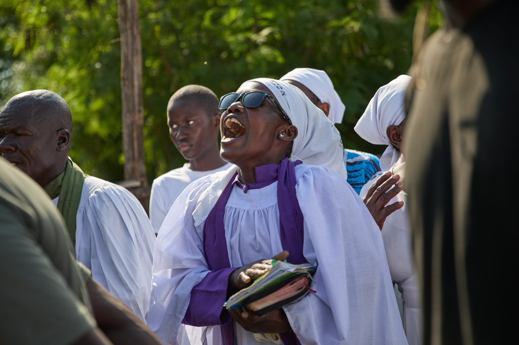 A member of a church choir sings during a funeralon the outskirts of Kisumu, Kenya, Friday, March 13, 2026. (AP Photo/Asa Wallin)