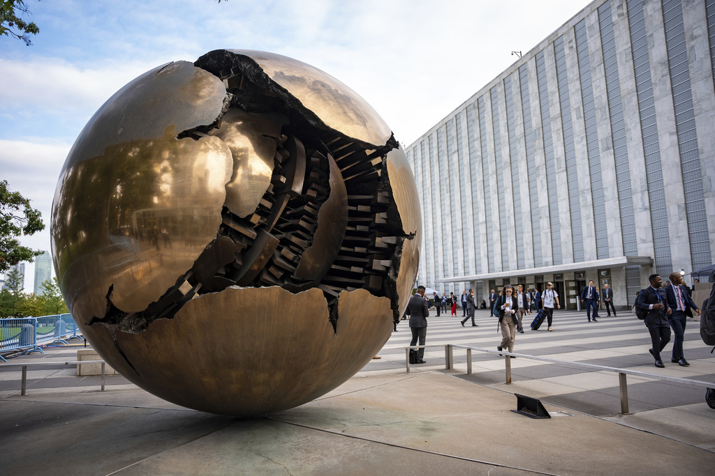 People walk around the plaza by the Sphere Within Sphere outside the United Nations Headquarters on the first day of the 80th session of the UN General Assembly's High-Level week, Monday, Sept. 22, 2025. (AP Photo/Angelina Katsanis)