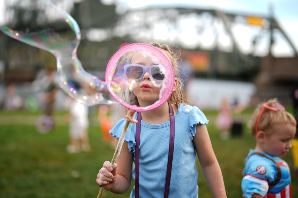 Ava Conda, 6, of Minneapolis, blows bubbles during the annual Harvest Festival, Sunday, Oct. 11, 2026, in Stillwater, Minn. (AP Photo/Ellen Schmidt)