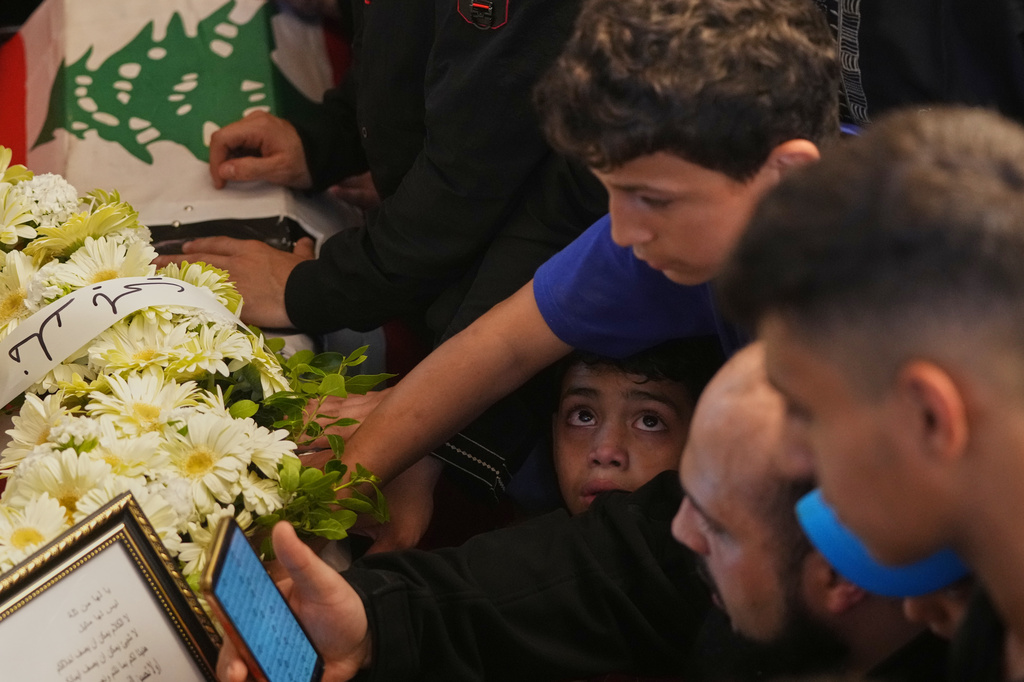 A boy reacts as mourners gather around the coffins of Palestinian fighters Hozeifa Hamza Ghannamieh and Ibrahim Anwar al-Khalayli, who were killed while fighting alongside Hezbollah against Israel in southern Lebanon, during their funeral in Beirut, Lebanon, Tuesday, April 28, 2026. (AP Photo/Hassan Ammar)