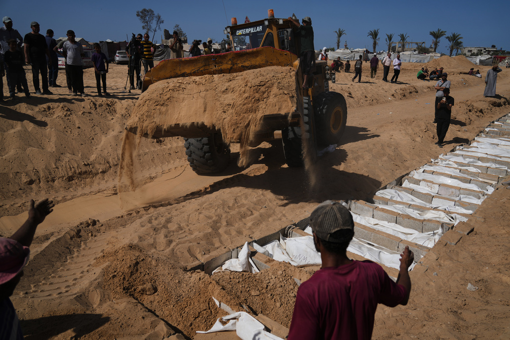 Bodies of unidentified Palestinians returned from Israel as part of the ceasefire deal are buried in a mass grave in Deir al-Balah, Gaza Strip, Wednesday, Oct. 22, 2025. (AP Photo/Jehad Alshrafi)