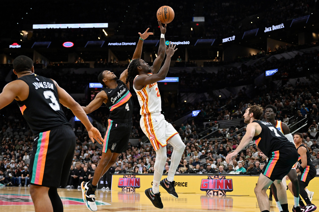 Atlanta Hawks guard Keaton Wallace (2) goes to the basket against San Antonio Spurs guard De'Aaron Fox (4) during the first half of an NBA basketball game, Thursday, Nov. 20, 2025, in San Antonio. (AP Photo/Darren Abate)