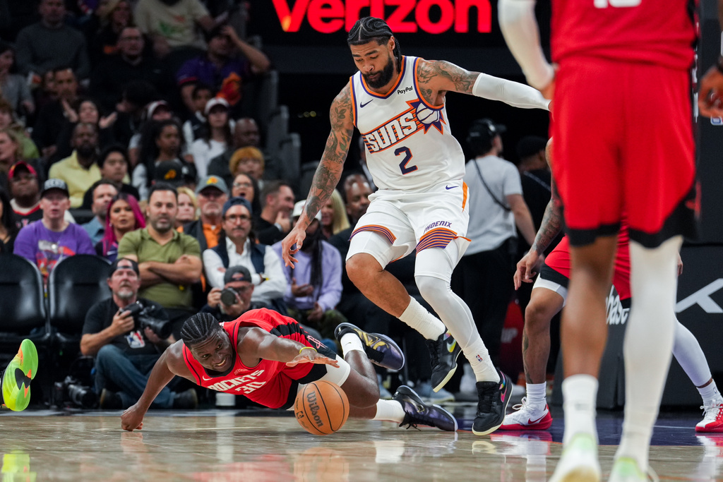 Phoenix Suns center Nick Richards (2) and Houston Rockets center Clint Capela (30) reach for the ball during the first half of an NBA basketball game, Monday, Nov. 24, 2025, in Phoenix. (AP Photo/Samantha Chow)