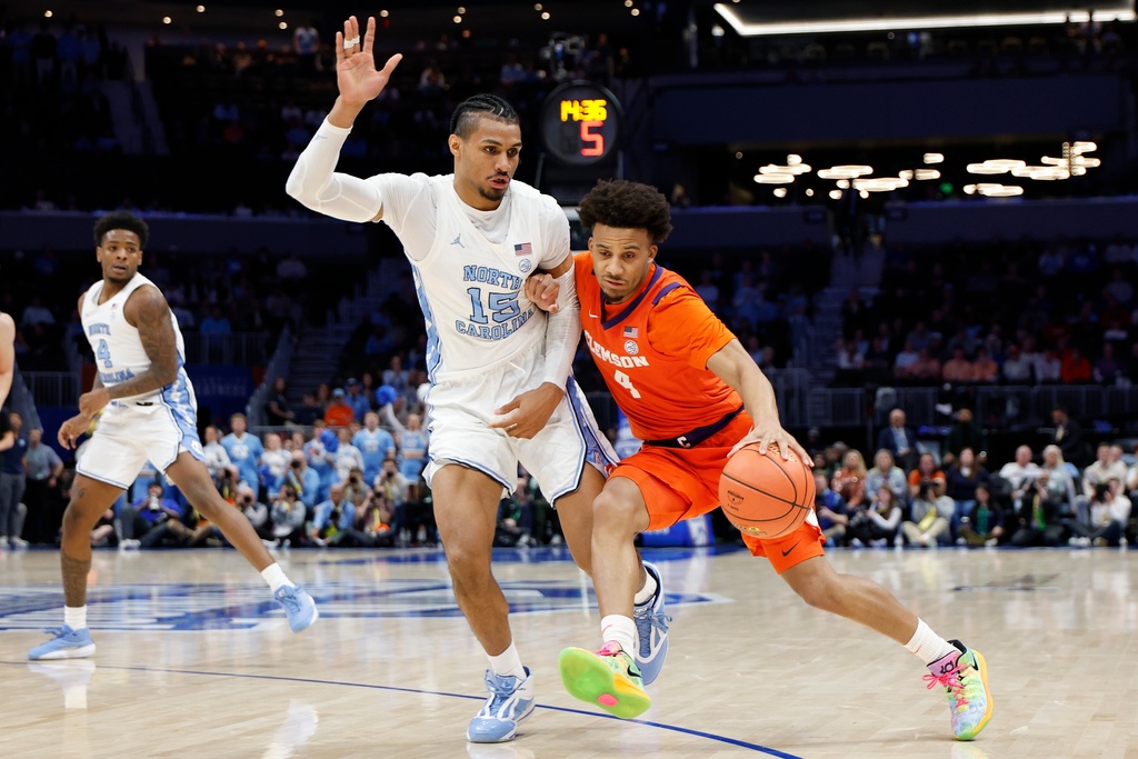 Clemson guard Efrem Johnson (4) drives against North Carolina forward Jarin Stevenson during the second half of an NCAA college basketball game in the quarterfinals of the Atlantic Coast Conference tournament in Charlotte, N.C., Thursday, March 12, 2026. (AP Photo/Nell Redmond)