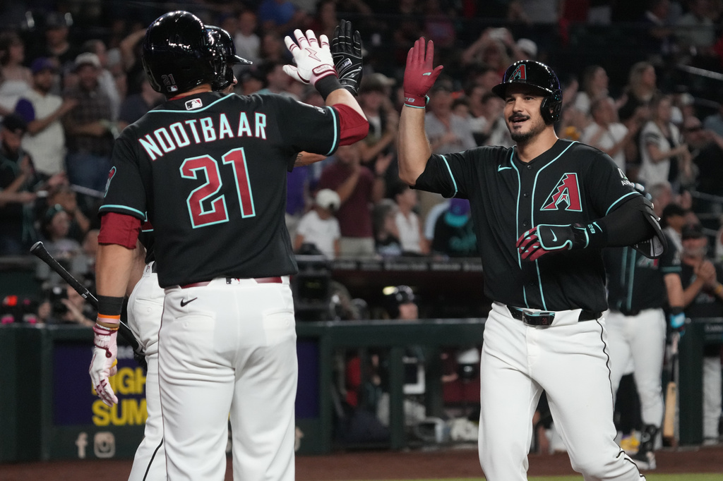 Arizona Diamondbacks' Nolan Arenado, right, celebrates with Tyler Locklear, back left, and Lars Nootbaar (21) after hitting a grand slam against the Colorado Rockies in the second inning of a baseball game, Monday, Aug 10, 2026, in Phoenix. (AP Photo/Rick Scuteri)
