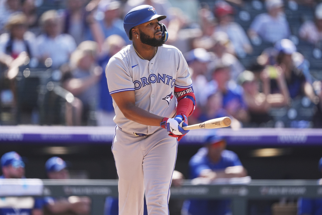 Toronto Blue Jays' Vladimir Guerrero Jr. follows the flight of his solo home run off Colorado Rockies relief pitcher Victor Vodnik in the eighth inning of a baseball game Wednesday, Aug. 6, 2025, in Denver. (AP Photo/David Zalubowski)