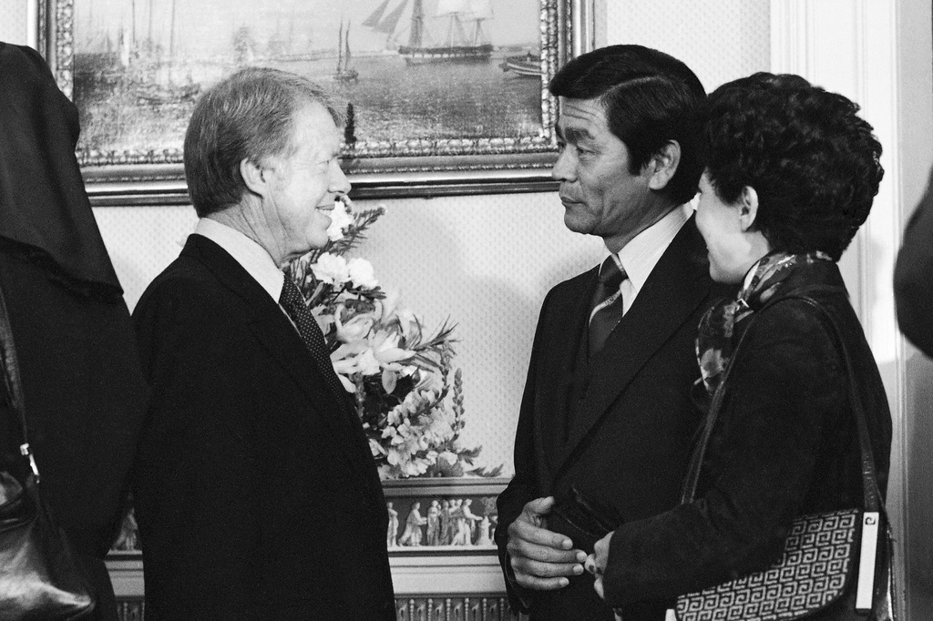 FILE - Hawaii Gov. George Ariyoshi, center, and his wife Jean chat with President Jimmy Carter during a White House reception for governors in Washington, Jan. 21, 1977. (AP Photo, File)