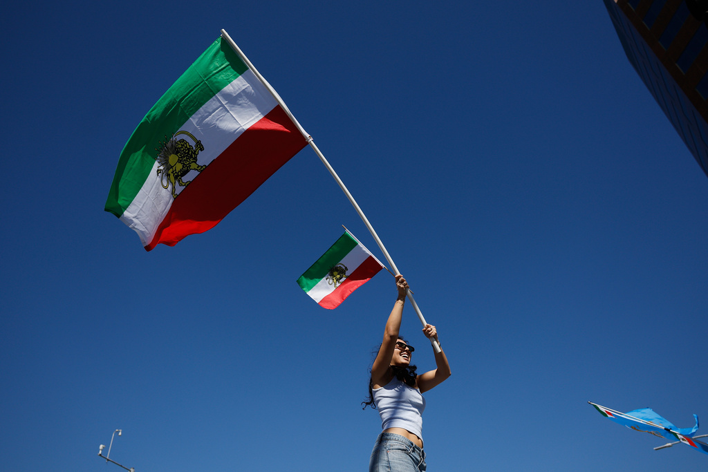 A demonstrator waves Iranian flags in reaction to the U.S. and Israeli strikes on Iran on Saturday, Feb. 28, 2026, in Los Angeles. (AP Photo/Caroline Brehman)