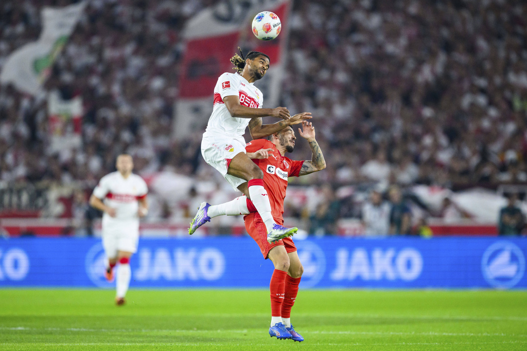 St. Pauli's Mathias Pereira Lage, right, and VfB Stuttgart's Lorenz Assignon, vie for the ball during the German Bundesliga soccer match between VfB Stuttgart and FC St. Pauli in Stuttgart, Germany, Friday, Sept. 19, 2025. (Tom Weller/dpa via AP)