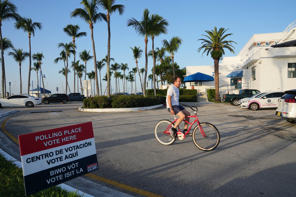 A cyclist rides past a voting precinct at Miami City Hall during the Florida primary election, Tuesday, Aug. 18, 2026, in Miami. (AP Photo/Lynne Sladky)