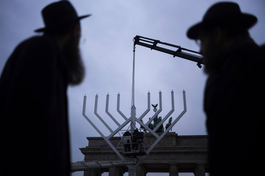 FILE - Rabbi Yehuda Teichtal, right, and Rabbi Shmuel Segal, left, watch the set-up of a giant Hanukkah Menorah by the Jewish Chabad Educational Center ahead of the Jewish Hanukkah holiday, in front of the Brandenburg Gate at the Pariser Platz in Berlin, Germany, Monday, Dec. 23, 2024. (AP Photo/Markus Schreiber, File)