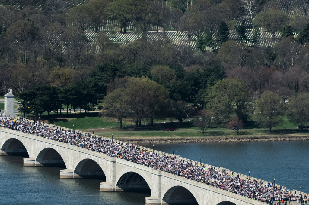 Demonstrators march across Memorial Bridge during the No Kings protest in Washington, Saturday, March 28, 2026. (AP Photo/Allison Robbert)