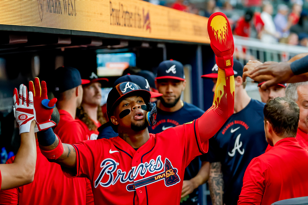 Atlanta Braves' Ronald Acuña Jr., center, is greeted in the dugout after scoring against the Colorado Rockies during the second inning of a baseball game, Friday, Aug. 28, 2026, in Atlanta. (AP Photo/Erik S. Lesser)