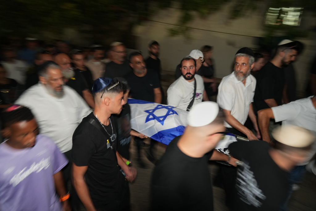 Relatives and friends carry the body of Israeli slain hostage Eitan Levi after his body was returned from Gaza as part of a ceasefire agreement between Israel and Hamas, at Bat Yam cemetery, in Holon, Israel, Thursday, Oct. 16, 2025. (AP Photo/Francisco Seco)