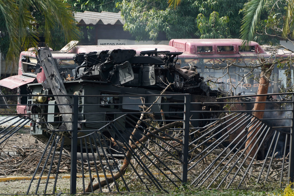 A destroyed armored vehicle sits at La Carlota airport in Caracas, Venezuela, Saturday, Jan. 3, 2026, after explosions were reported at the site. (AP Photo/Ariana Cubillos)