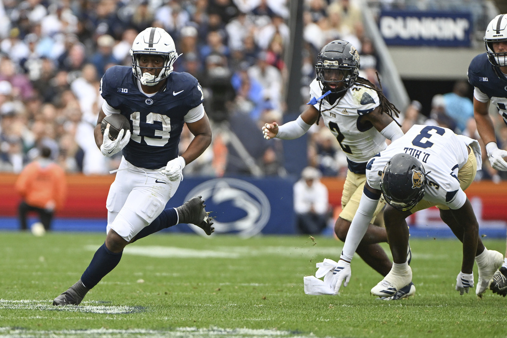 Penn State running back Kaytron Allen (13) runs away from Florida International defensive back Demetrius Hill (3) during the first half of an NCAA college football game, Saturday, Sept. 6, 2025, in State College, Pa. (AP Photo/Barry Reeger)
