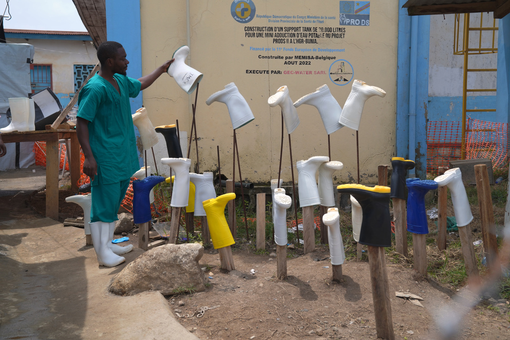 Un trabajador de salud pone a secar botas recién lavadas para evitar la propagación del virus del ébola en un centro de atención en el Hospital General de Bunia, el martes 11 de agosto de 2026, en la provincia de Ituri, República Democrática del Congo. (AP Foto/Dieudonne Dirole)