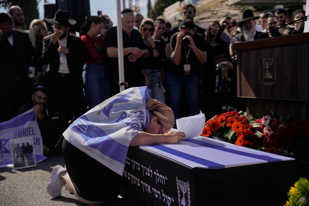 Naomi Baruch grieves over the coffin of her son, Uriel Baruch, a slain hostage whose body was returned from Gaza as part of a ceasefire agreement between Israel and Hamas, in Jerusalem, Sunday, Oct. 19, 2025. (AP Photo/Ohad Zwigenberg)