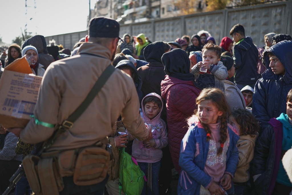 Civilians evacuate an area of the Sheikh Maqsoud neighborhood, where clashes between government forces and Kurdish fighters have been taking place in the northern city of Aleppo, Syria, Saturday, Jan. 10, 2026. (AP Photo/Ghaith Alsayed)