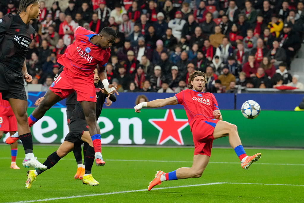 PSG's Willian Pacho heads the ball to score his side's first goal during a Champions League opening phase soccer match between Bayer Leverkusen and Paris Saint-Germain in Leverkusen, Germany, Tuesday, Oct. 21, 2025. (AP Photo/Martin Meissner)