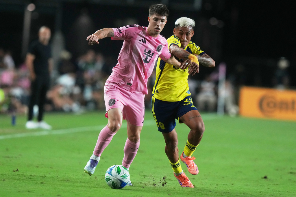 Inter Miami midfielder Baltasar Rodríguez (11) and Nashville SC midfielder Andy Najar (31) go after the ball during the first half of match one of an MLS playoff opening round soccer match Friday,, Oct. 24, 2025, in Fort Lauderdale, Fla. (AP Photo/Marta Lavandier)