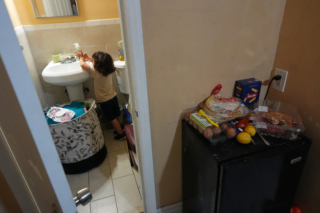 Jakelin Pasedo's three-year-old son washes his hands in the Miami-area motel room where Pasedo and her two children, who all have refugee status, are living, Wednesday, Oct. 22, 2025, after their father requested to be sent back to Venezuela after months in immigration detention. (AP Photo/Rebecca Blackwell)