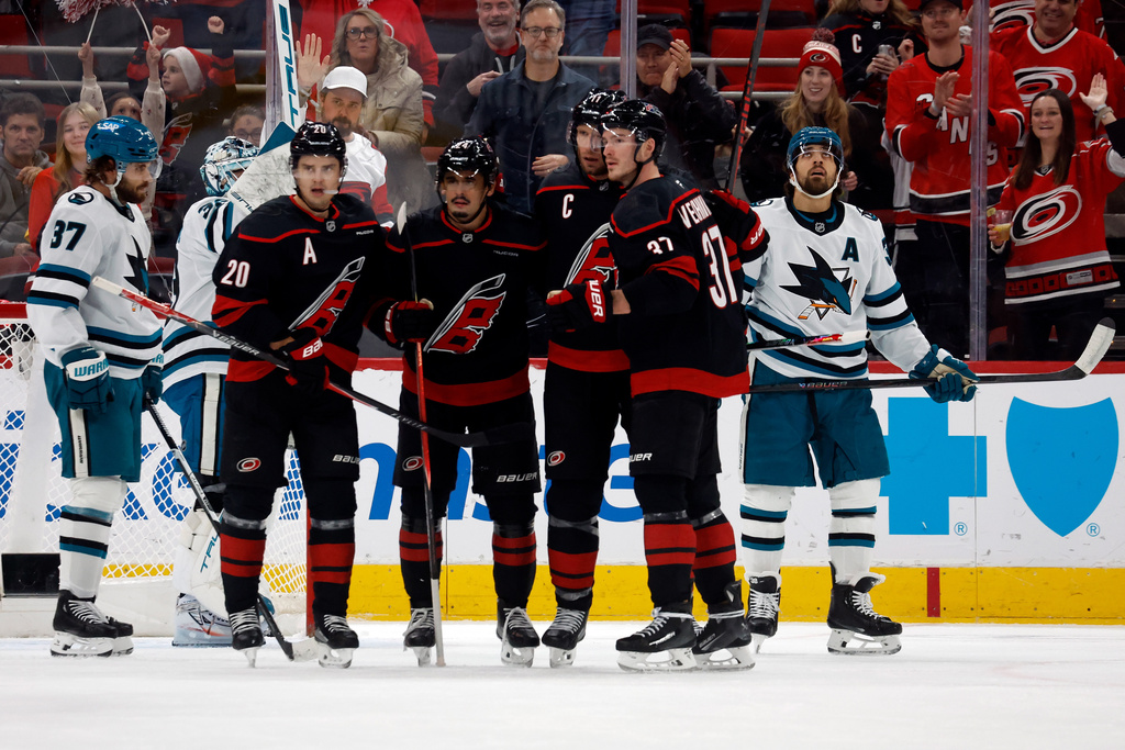 Carolina Hurricanes celebrate a goal by Jordan Staal, third right, as San Jose Sharks' Mario Ferraro (38) and Timothy Liljegren (37) stand nearby during the first period of an NHL hockey game, in Raleigh, N.C., Sunday, Dec. 7, 2025. (AP Photo/Karl DeBlaker)