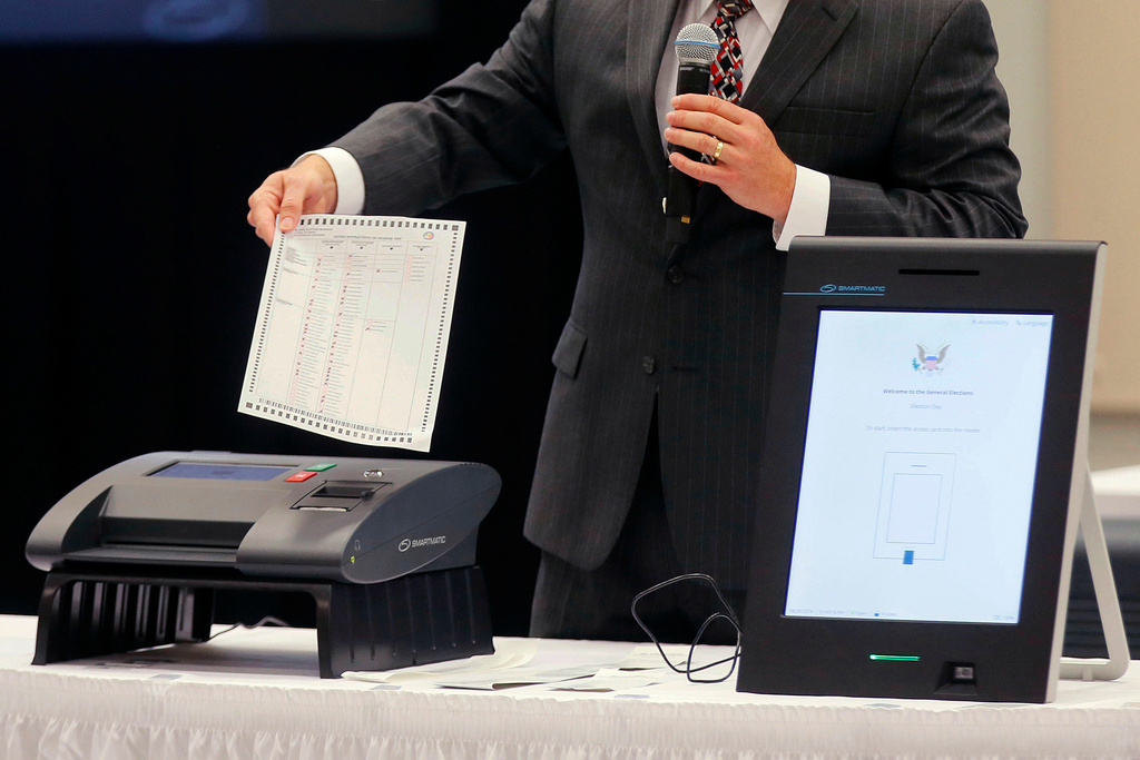 FILE - A Smartmatic representative demonstrates his company's system which has scanners and touch screens with printout options, at a meeting of the Secure, Accessible & Fair Elections Commission, Aug. 30, 2018, in Grovetown, Ga. (Bob Andres/Atlanta Journal-Constitution via AP, File)