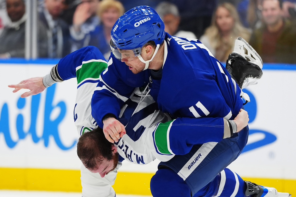 Toronto Maple Leafs' Max Domi (11) and Vancouver Canucks' Marcus Pettersson, bottom, fight during second-period NHL hockey game action in Toronto, Saturday, Jan. 10, 2026. (Frank Gunn/The Canadian Press via AP)