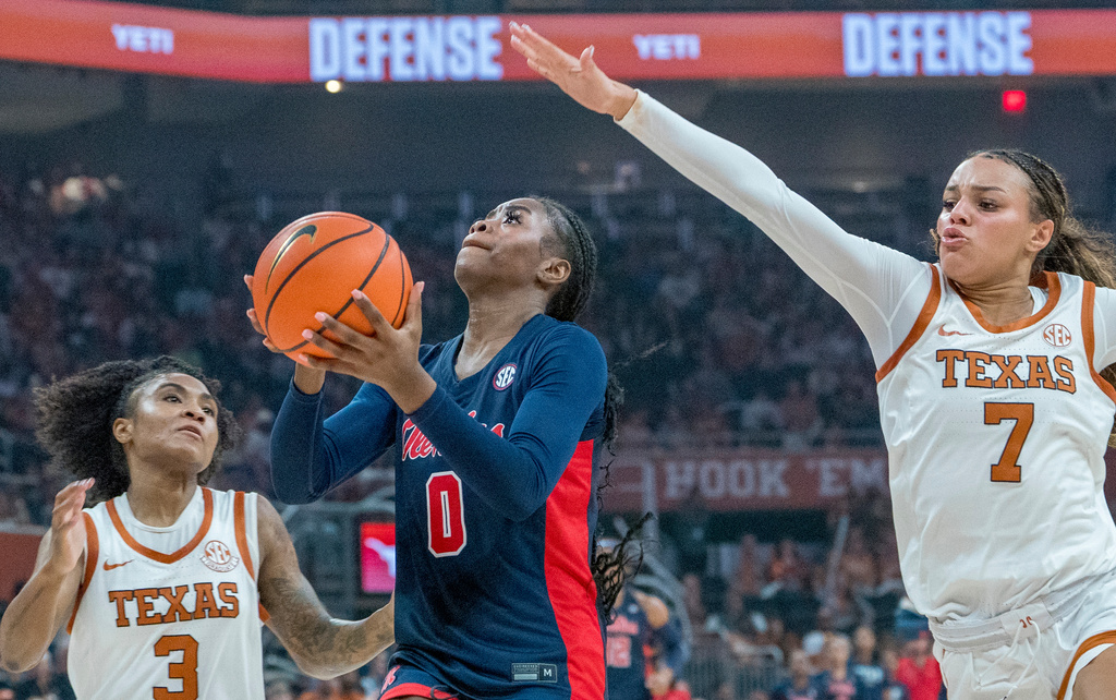 Mississippi guard Sira Thienou (0) drives to the basket as Texas guards Rori Harmon (3) and Jordan Lee (7) defend during the first half of an NCAA college basketball game in Austin, Texas, Sunday, Jan. 4, 2026. (AP Photo/Rodolfo Gonzalez)