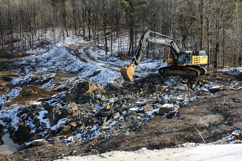 An excavator moves rocks at a graphite mine, Nov. 20, 2025, in Gouverneur, N.Y. (AP Photo/Michael Hill)