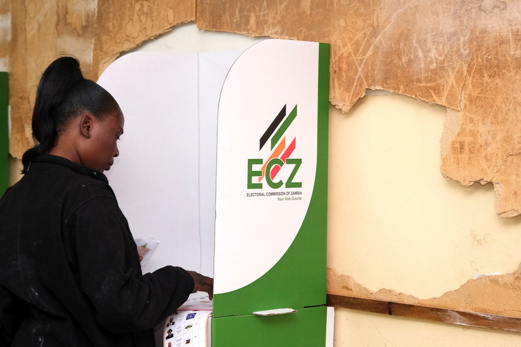 A woman is seen in a voting booth at a polling station in Lusaka, Zambia, Thursday, Aug. 13, 2026. (AP Photo/Anita Reed)
