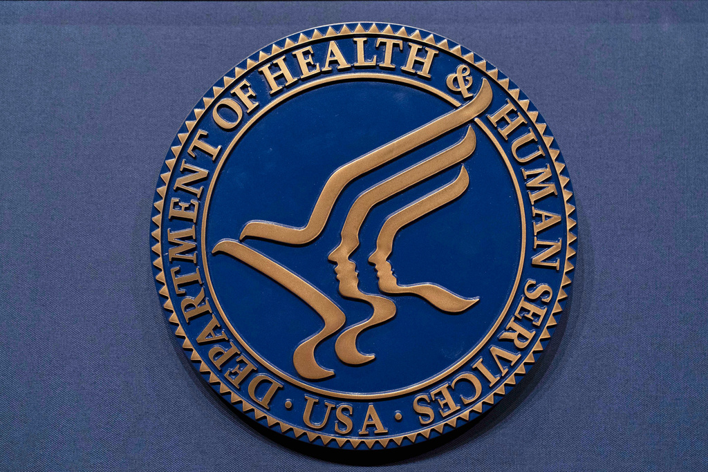 FILE = The Health and Human Services seal is seen before the news conference of Secretary Robert F. Kennedy Jr. at the Hubert Humphrey Building Auditorium in Washington, Wednesday, April 16, 2025. (AP Photo/Jose Luis Magana, File)