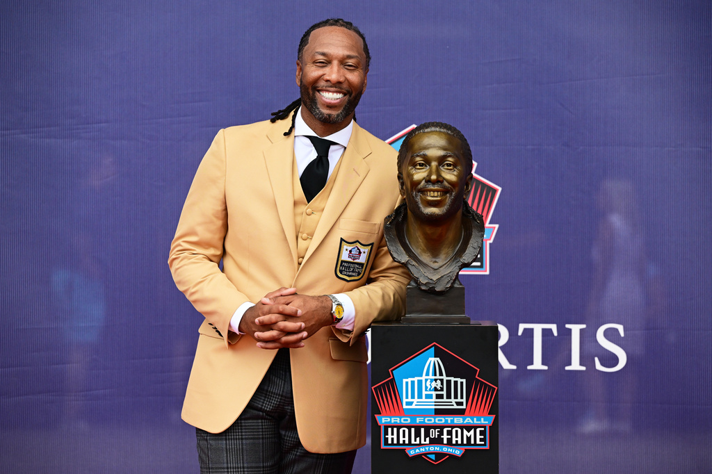 Former NFL player Larry Fitzgerald poses with his bust during the Pro Football Hall of Fame induction ceremony at the Pro Football Hall of Fame, in Canton, Ohio, Saturday, Aug. 8, 2026. (AP Photo/David Dermer)