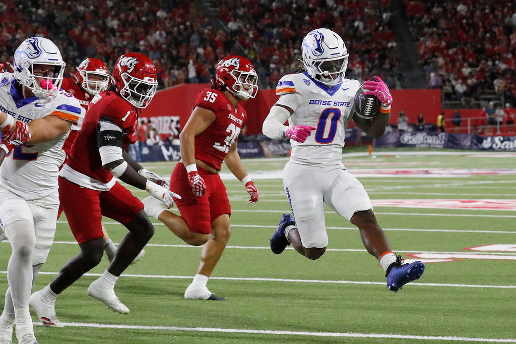 Boise State running back, Dylan Riley, looks to score past Fresno State defenders during the first half of an NCAA college football game, Saturday, Oct. 10, 2026, in Fresno, Calif. (AP Photo/Gary Kazanjian)