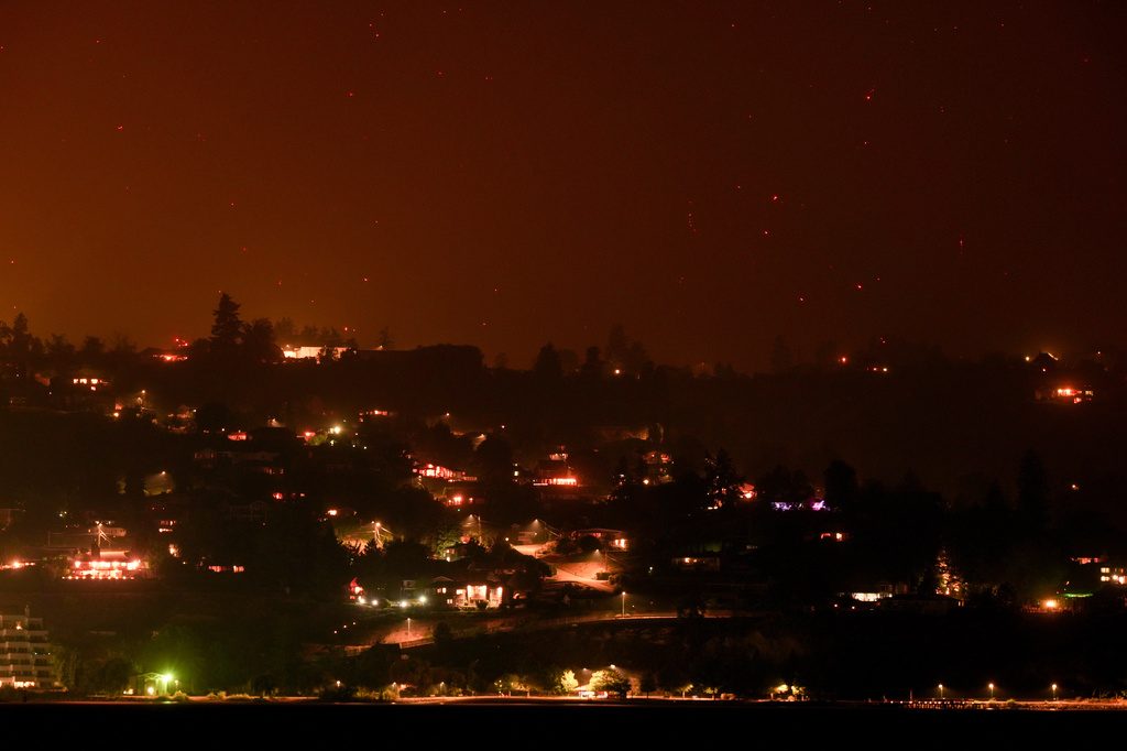 Hot spots from the Bald Range wildfire burn on the mountainside above houses in Summerland, British Columbia, late Saturday, Aug. 8, 2026. (Darryl Dyck/The Canadian Press via AP)